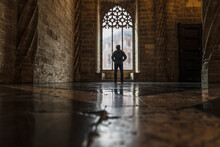 Spain, Valencia, Rear View Of Man Looking Through Window In Old Empty Church