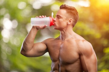 Wall Mural - A sporty young person drinking water