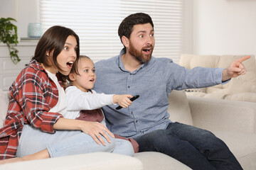 Canvas Print - Surprised family watching TV on sofa at home