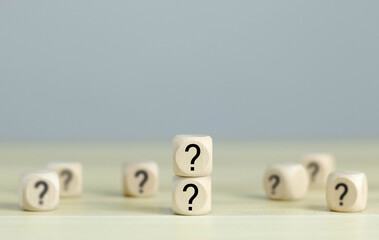 Question mark, Confused, Thinking, Brainstorming or Decision, Problem Solving, Finding Answer, Question. Marked words in wooden blocks on table top.	