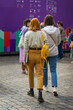 View from behind young girls walking together at city exhibition. Regular people out in public places