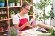 © Krakenimages.com - Young beautiful hispanic woman florist smiling confident counting dollars at florist