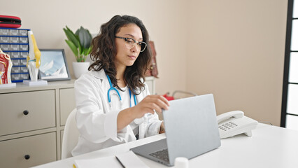 Sticker - Young beautiful hispanic woman doctor opening laptop working at clinic