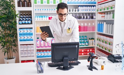 Sticker - Young hispanic man pharmacist using touchpad and computer at pharmacy