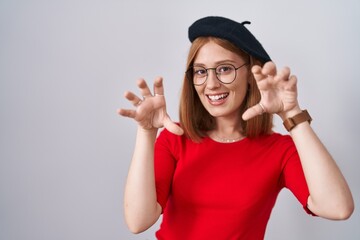 Poster - Young redhead woman standing wearing glasses and beret smiling funny doing claw gesture as cat, aggressive and sexy expression