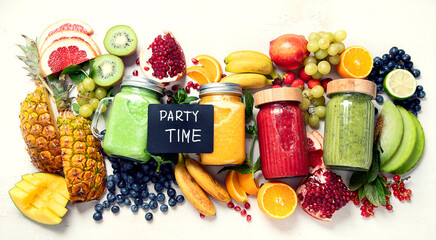 Fresh fruit and vegetable smoothies or juice  with various ingredients on light background.