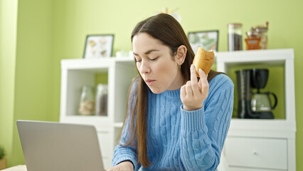 Wall Mural - Young caucasian woman using laptop having breakfast at dinning room