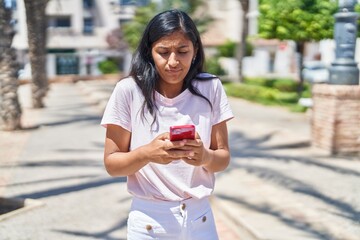 Sticker - Young beautiful hispanic woman using smartphone at street