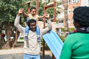 Wall Mural - African american family holding boy on shoulders at playground