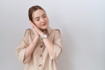 Sticker - Young caucasian woman wearing casual shirt sleeping tired dreaming and posing with hands together while smiling with closed eyes.