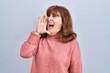 © Krakenimages.com - Middle age hispanic woman standing over isolated background shouting and screaming loud to side with hand on mouth. communication concept.
