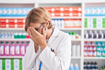 Poster - Caucasian man with mustache working at pharmacy drugstore with sad expression covering face with hands while crying. depression concept.