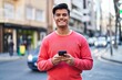 © Krakenimages.com - Young hispanic man smiling confident using smartphone at street