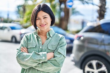 Sticker - Young chinese woman smiling confident standing with arms crossed gesture at street