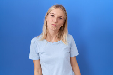 Poster - Young caucasian woman wearing casual blue t shirt looking at the camera blowing a kiss on air being lovely and sexy. love expression.