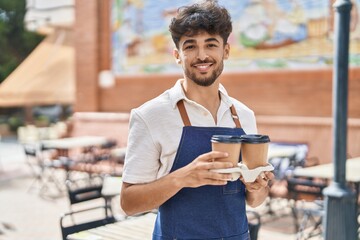 Sticker - Young arab man waiter smiling confident holding take away coffee at restaurant