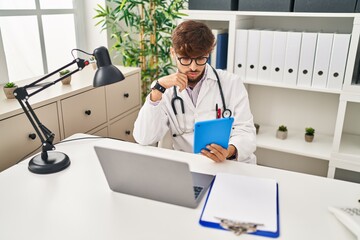 Young arab man wearing doctor uniform using touchpad at clinic