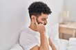 © Krakenimages.com - Young arab man suffering for ear pain sitting on bed at bedroom
