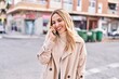 © Krakenimages.com - Young blonde woman smiling confident talking on smartphone at street