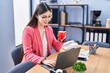 © Krakenimages.com - Chinese woman business worker using laptop drinking coffee at office