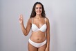 © Krakenimages.com - Young hispanic woman wearing white lingerie showing and pointing up with fingers number three while smiling confident and happy.