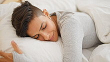 Young Beautiful Hispanic Woman Lying On Bed Sleeping At Bedroom