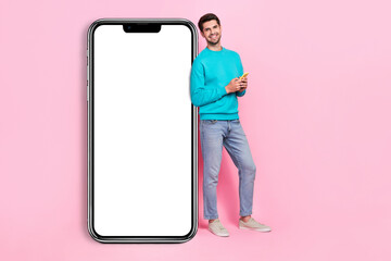 Wall Mural - Full length photo of attractive young man blank copyspace hold device gadget dressed stylish blue outfit isolated on pink color background