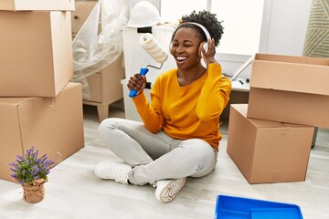 Wall Mural - African american woman listening to music singing song at new home