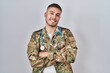 © Krakenimages.com - Young hispanic doctor wearing camouflage army uniform happy face smiling with crossed arms looking at the camera. positive person.