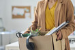 © Mediaphotos - Close-up of businesswoman packing things in box while moving in new office