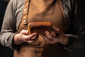 Wall Mural - Small brown bread in hands, domestic cozy bakery pastry. Healthy food concept. place for text