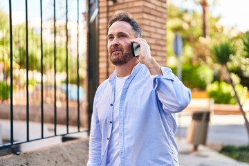 Poster - Young caucasian man talking on the smartphone with serious expression at street