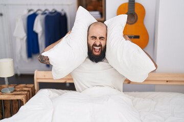 Wall Mural - Young bald man covering ears for noise at bedroom