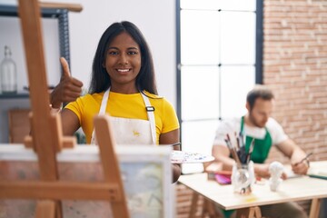 Wall Mural - Indian woman at art studio smiling happy and positive, thumb up doing excellent and approval sign