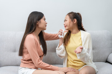 Two women talking about problems at home. Asian women embrace to calm their sad best friends from feeling down. Female friends supporting each other. Problems, friendship, and care concept