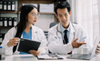 © NINENII - Doctors working together on digital tablet healthcare doctor technology tablet using computer in a modern office.