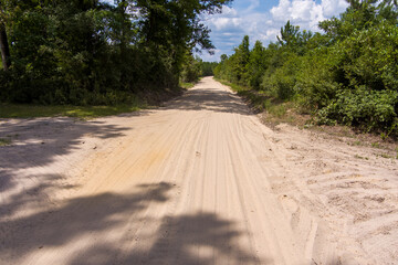 Wall Mural - Aerial view of a dusty dirt road in Southeastern Texas with a diminishing perspective