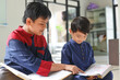 © Queenmoonlite Studio - Asian Muslim boy reading Quran and teaching his brother or friend how to read holy Quran inside the mosque