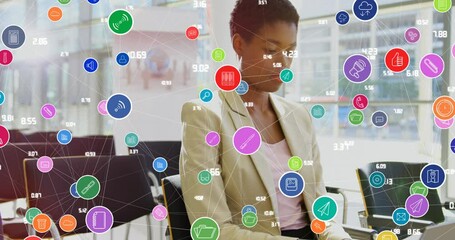 Wall Mural - Animation of connected icons with numbers over short hair african american woman working on laptop