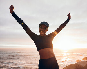 Poster - Portrait of woman celebrate by ocean for fitness in nature for exercise, marathon training and running goals. Sports, sunset and female person with hands in air for winning, workout and wellness