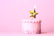 Pink birthday cake with gold star birthday candle