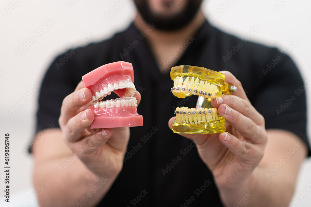Orthodontist performing metal dental braces and clear aligners on ...