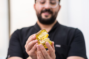 Aufkleber - Orthodontist showing artificial human jaws from yellow plastic with installed metal braces for professional teeth correction doctor consulting patient in hospital