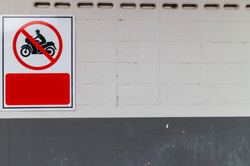 Sign forbidden to drive motorcycles on the building attached to the corridor wall