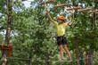 © Daniel CHETRONI - Boy enjoys climbing in the ropes course adventure. Happy boys playing at adventure park holding ropes and climbing wooden stairs