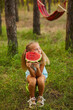 © Inna Vlasova - Cute girl eating watermelon at park in the forest