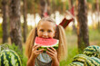 © Inna Vlasova - Cute girl eating watermelon at park in the forest
