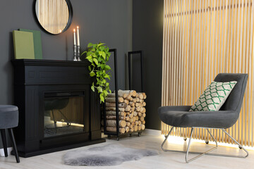 Poster - Stylish room with beautiful fireplace, houseplant and comfortable chair. Interior design