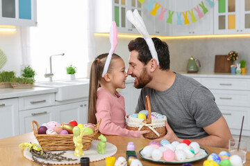 Canvas Print - Father and his cute daughter with wicker basket full of Easter eggs in kitchen