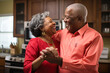 © MVProductions - Authentic moment of an African American retired couple sharing a dance in the kitchen, an embodiment of enduring love and romance, generative ai